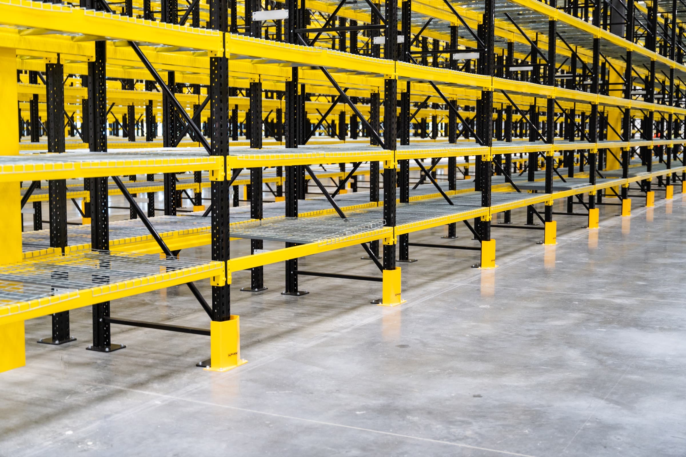 Detail view of pallet rack beams, wire deck, and column protectors